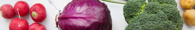Verdure fresche come pomodori, carote, broccoli e peperoni su marmo per una cucina sostenibile